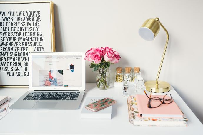 Espacio de trabajo con una laptop en un escritorio, lampara de mesa y elementos decorativos